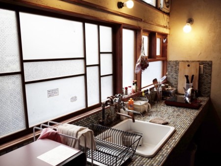 宿泊者が自炊をするための共用キッチン。窓は解体時にあちこちで出たガラスを再利用。